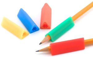 The teacher attaches a triangular pencil grip to support the child’s pencil grasp.